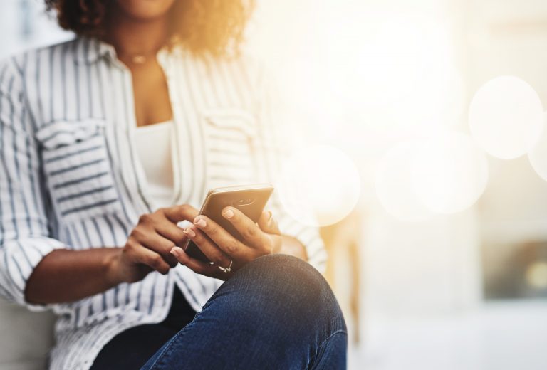 Close-up of a sitting woman on a smartphone