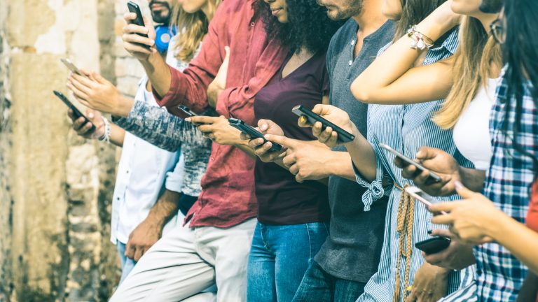 Side shot of a group of people using their smartphones